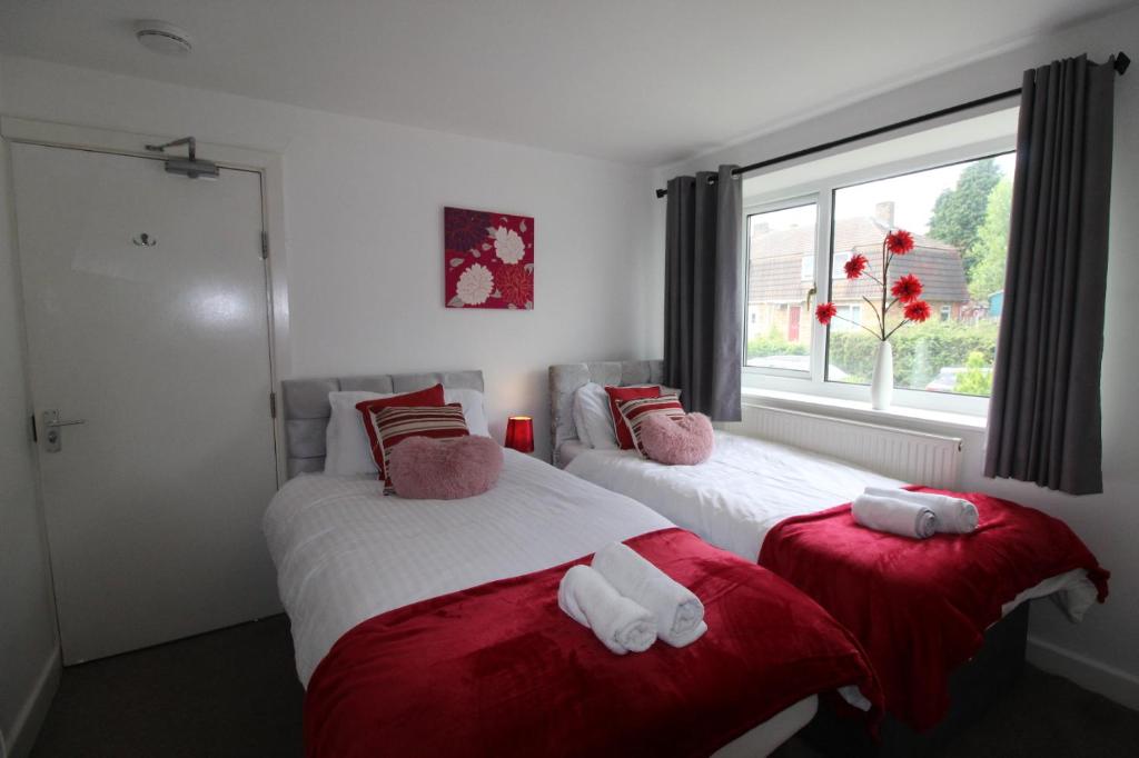 two beds in a room with a window at Hady House in Chesterfield