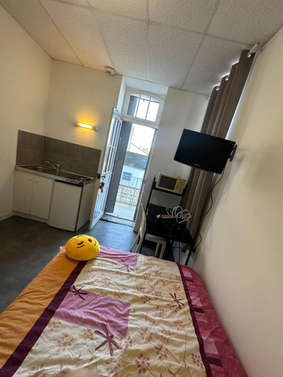 - une chambre avec un lit doté d'un oreiller jaune dans l'établissement Petit Studio Gare SNCF, à Tarbes
