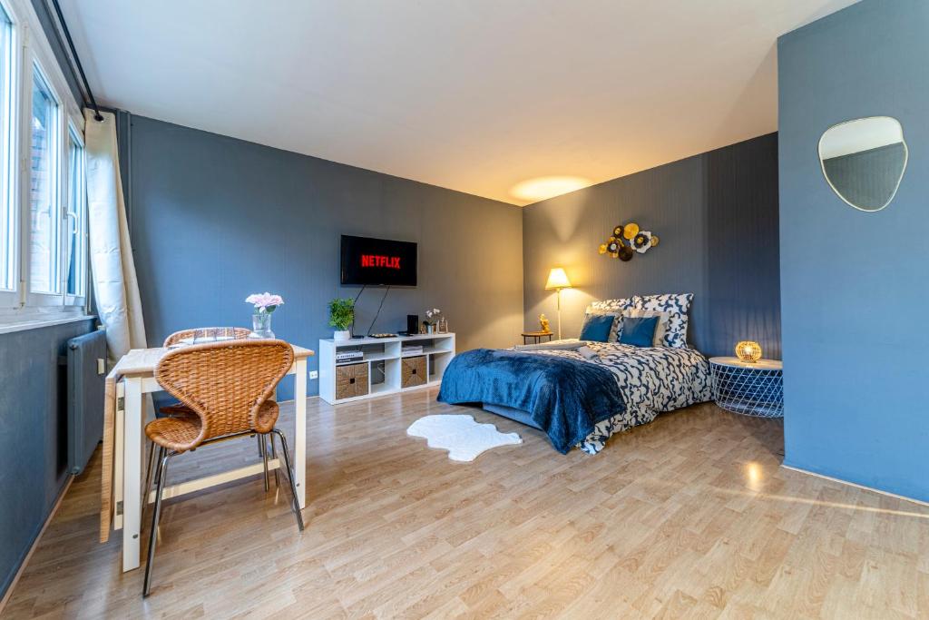 une chambre avec un lit, une table et un bureau dans l'établissement L'Azur - Parking privé - Hypercentre - Wifi, à Marcq-en-Barœul
