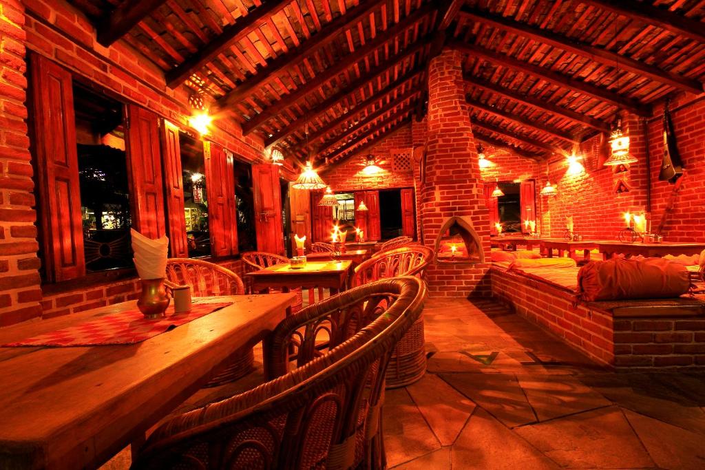 una sala da pranzo con tavolo e sedie in legno di Peace Eye Guest House a Pokhara