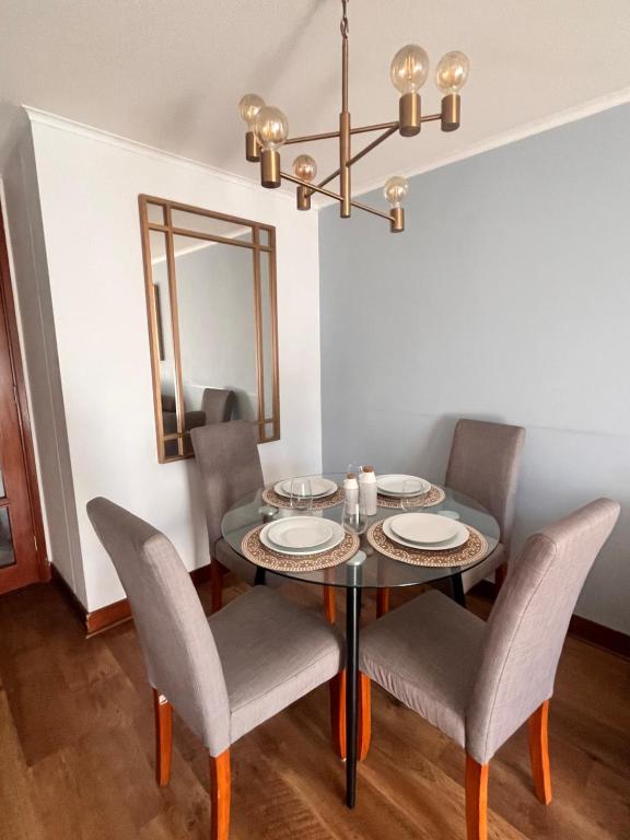 comedor con mesa con sillas y espejo en Departamento Nuevo en Ñuñoa full equipado, en Santiago