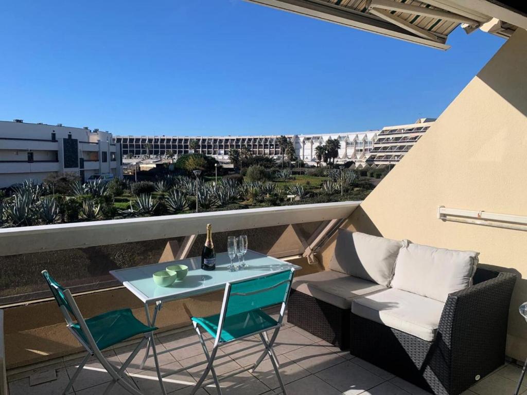 un patio avec une table et des chaises sur un balcon dans l'établissement Résidence Héliopolis Bâtiment Ab - Studio 4 pers - Héliopolis Bât. AB MAE-3044, au Cap d'Agde