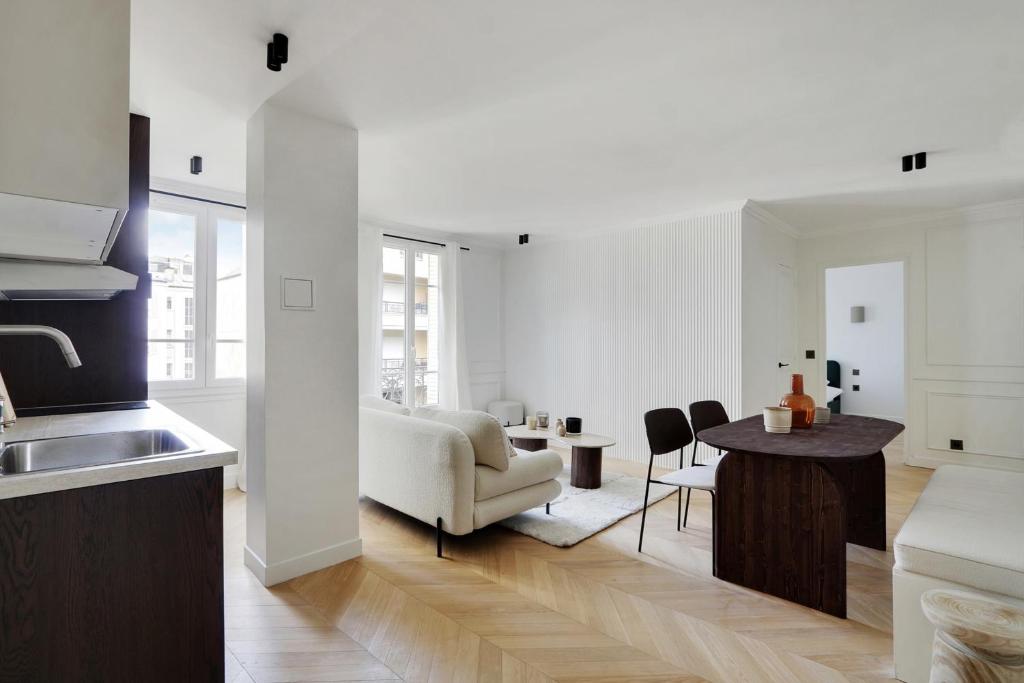a kitchen and living room with a couch and a table at VINCENNES Luxury flat L005 in Vincennes