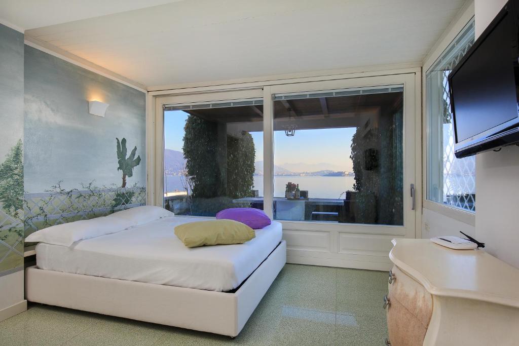 a bedroom with a bed and a large window at Maison du Lac in Stresa