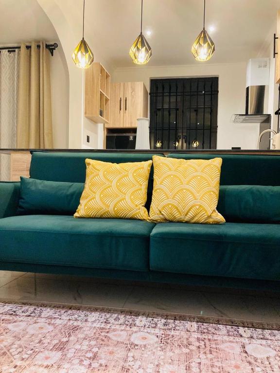 a blue couch with yellow pillows in a living room at Oceana Residence 2 in Mont Choisy