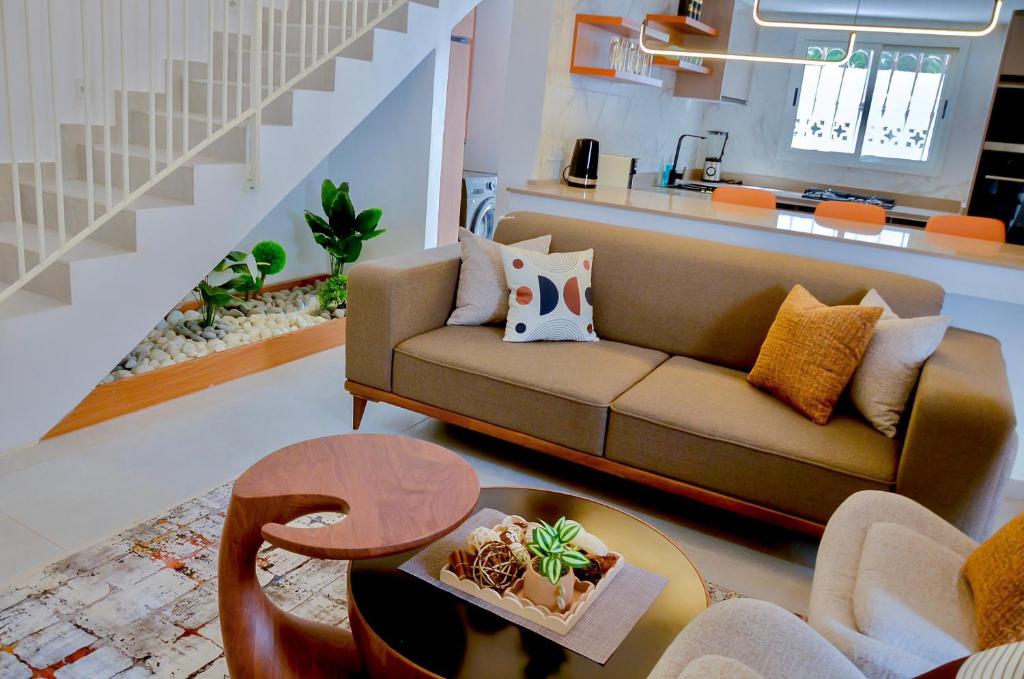 ein Wohnzimmer mit Sofa und Tisch in der Unterkunft La Villa Moringa, meublée et équipée in Saly Portudal