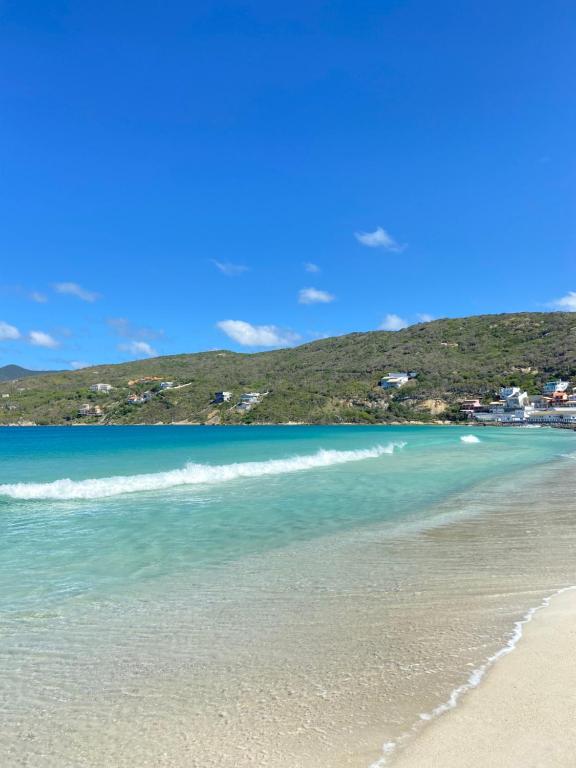 une vue d'une plage avec l'océan dans l'établissement Suíte Areia dos Anjos, à Arraial do Cabo