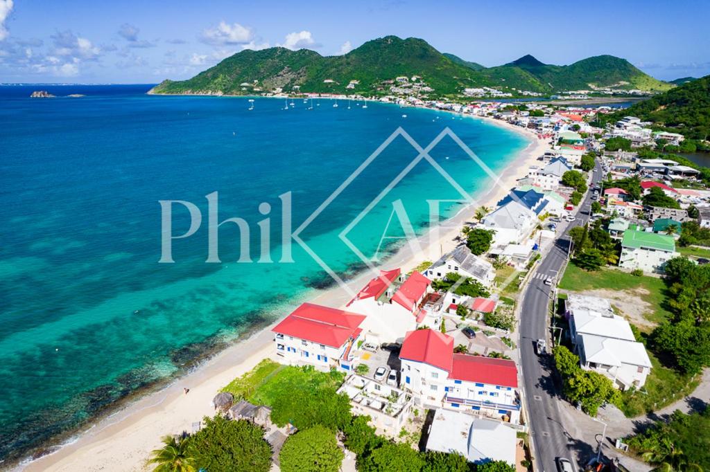 an aerial view of a beach with houses and the ocean at Bel appartement N4 neuf de 2 chambres à Grand-Case in Grand Case