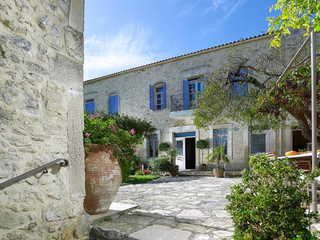 a large stone building with flowers in a courtyard at Villa Kerasia in Vlakhianá