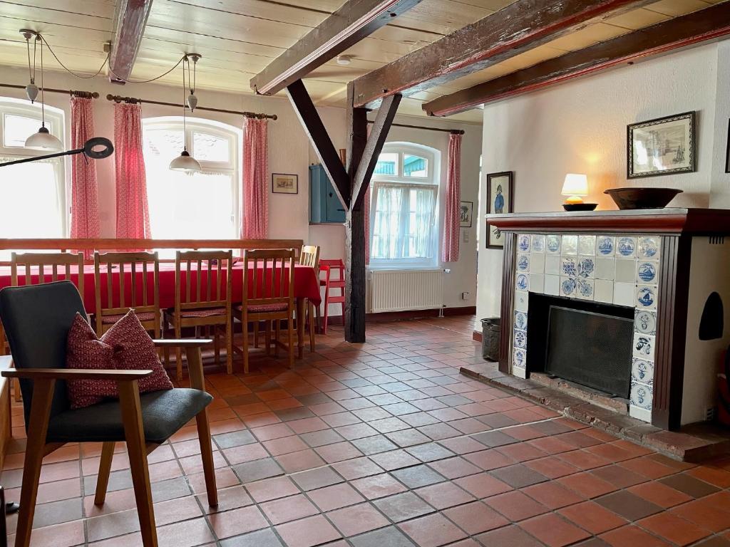 a dining room with a fireplace and a table and chairs at Drifthuus 2 groß in Spiekeroog