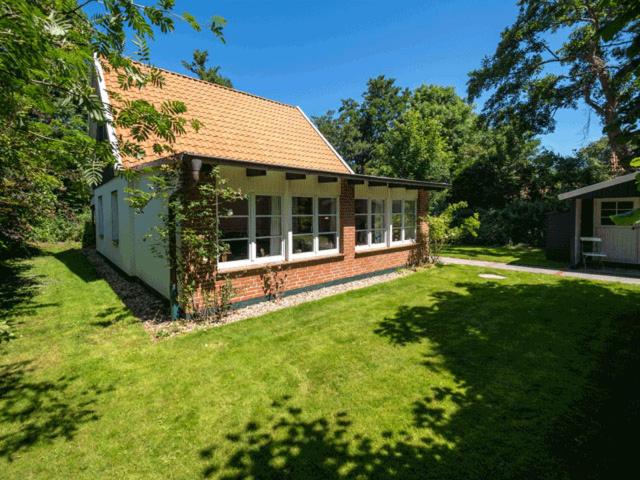 a small brick house with a grass yard at Pastors Tuun in Spiekeroog