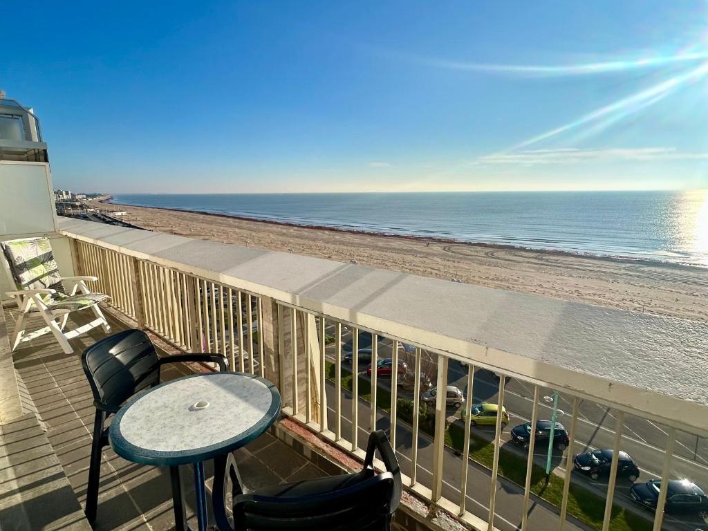 un balcon avec une table et des chaises et l'océan dans l'établissement Appartement bord de mer avec balcon et parking - FR-1-652-47, à Saint-Jean-de-Monts