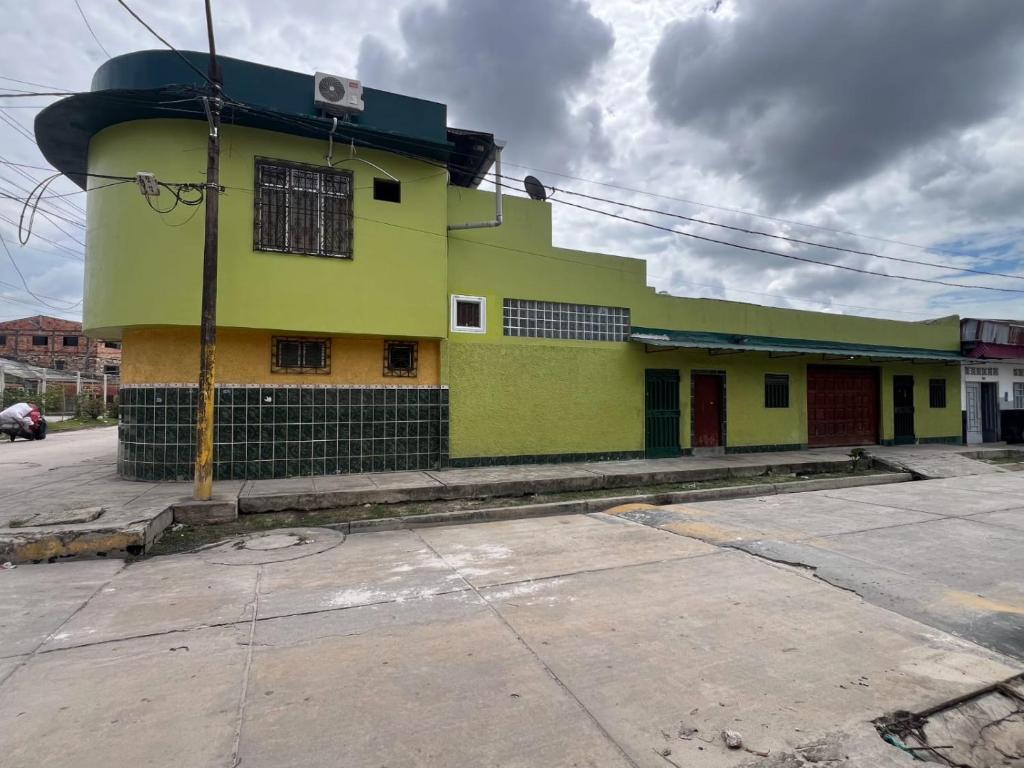 a yellow and green building on the side of a street at La Casa Verde in Iquitos