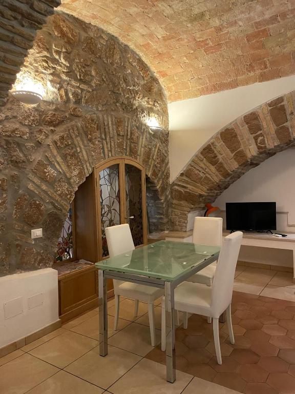 a dining room with a glass table and white chairs at Roman times experience in Monti area in Rome