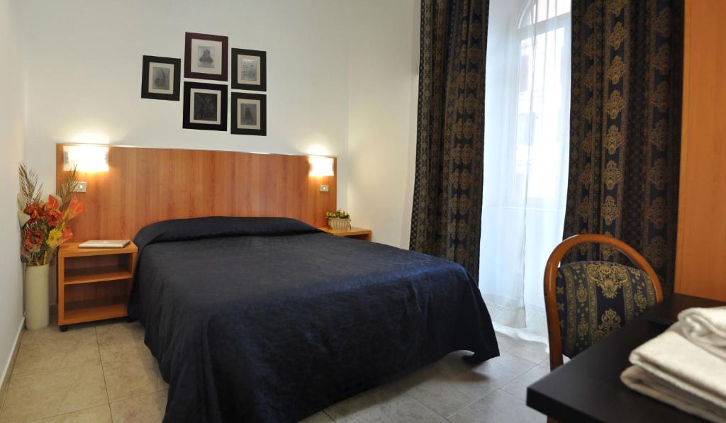 een slaapkamer met een bed, een tafel en een raam bij Hotel Fiorenza in Rome