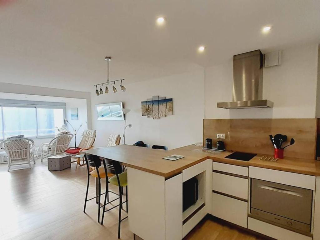 - une cuisine avec un comptoir et un îlot de cuisine dans une pièce dans l'établissement Appartement rénové 3 pièces avec parking et clim, proche plage - FR-1-782-72, au Barcarès
