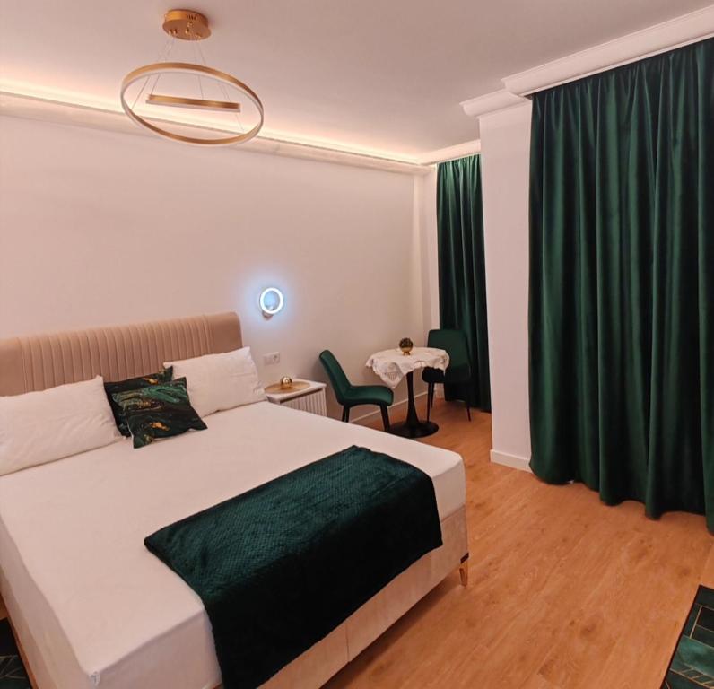 1 dormitorio con 1 cama grande y cortinas verdes en Apartament Gold Luxury 3, en Baia Mare