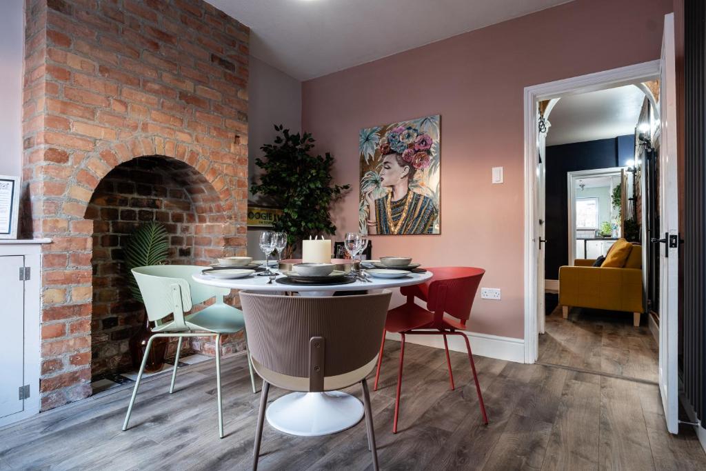 ウスターにあるLowell Street - Cosy 2 Bedroom Home in Worcester!のレンガの壁のダイニングルーム(テーブル、椅子付)