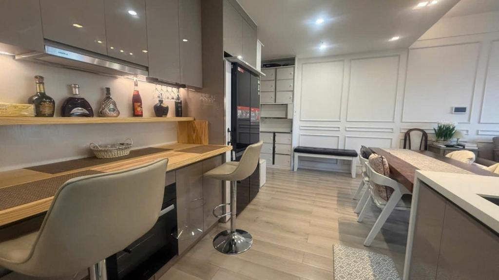 a kitchen with white cabinets and a table and chairs at Vinhome Grandpark TPHCM Vietnam Masteri Centre Point Luxury Apartment with Adventure at Your Doorstep - Amusement Park & Poolside Comfort! in Ho Chi Minh City