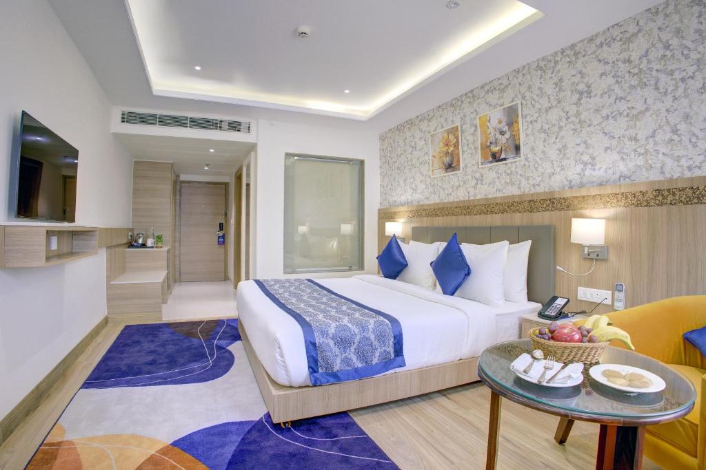a hotel room with a bed and a living room at Cygnett Inn Airport in Mohāna