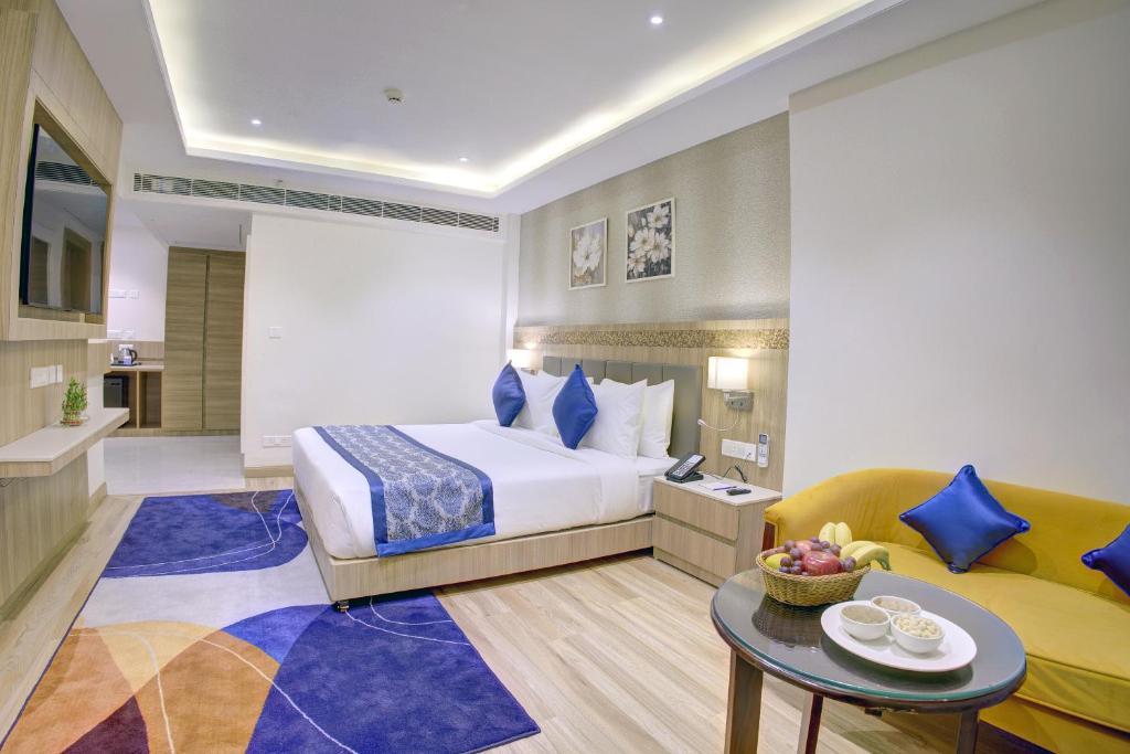 a hotel room with a bed and a couch at Cygnett Inn Airport in Mohāna