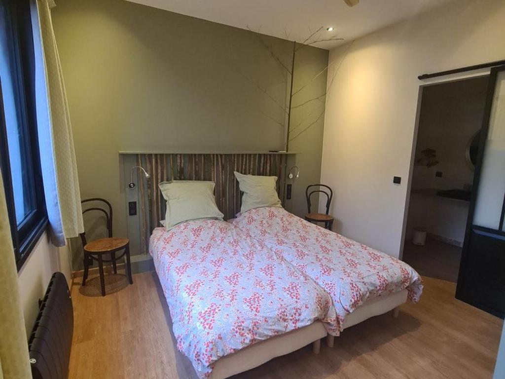 a bedroom with a large bed with a pink comforter at Chambre d'hôtes pour 2 pers. avec petit-déjeuner inclus - FR-1-590-506 in La Ferté-Saint-Aubin