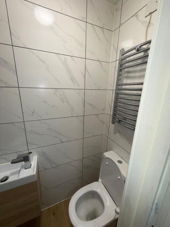 a white bathroom with a toilet and a sink at Riverside in London