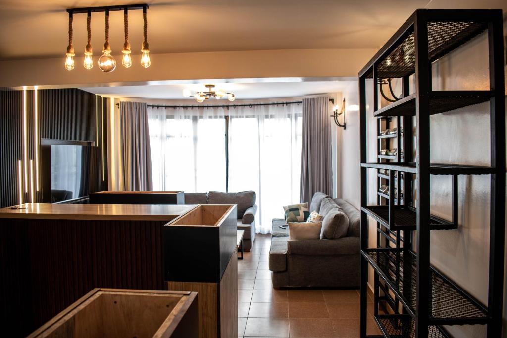 a living room with a kitchen and a living room with a couch at The Hause in Nakuru