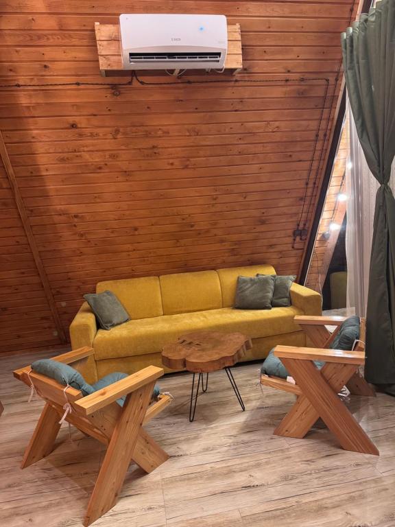 a living room with a yellow couch and a table at Yerankyun Boutique Cabin in Lermontovo
