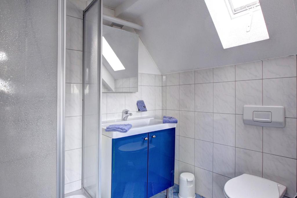 a bathroom with a blue cabinet and a sink at Hotel Bären Amriswil in Amriswil