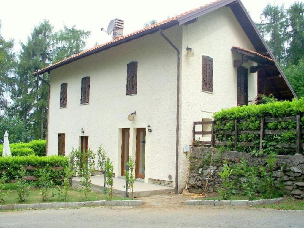 a white house with a fence in front of it at Cottage in Intra with Lake and Mountain Views in Verbania