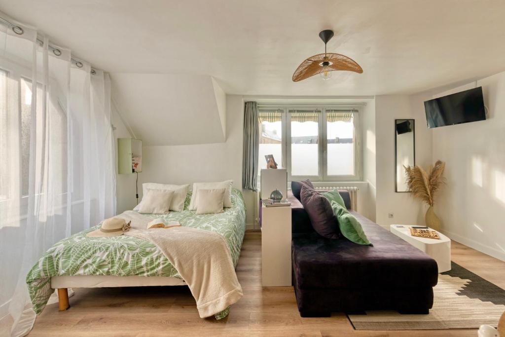 une chambre avec un lit, un canapé et une fenêtre dans l'établissement Le Cosy, à Lannion