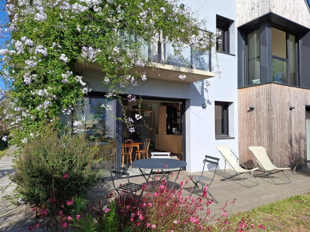 un patio avec des chaises et une table devant un bâtiment dans l'établissement Coup de cœur, bord de mer - jusqu'à 12 voyageurs !, à Sarzeau