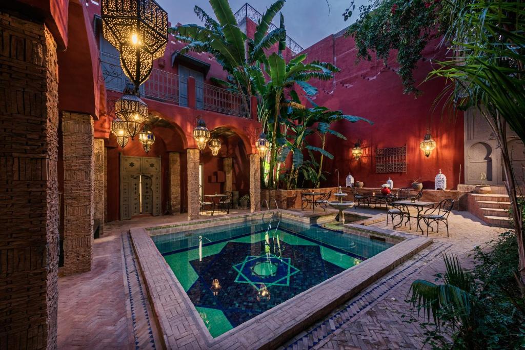 una piscina coperta in un cortile con una casa di Riad Les Jardins d'Henia a Marrakech