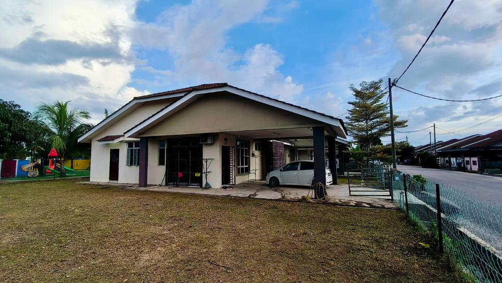 a small house with a car parked in front of it at Teratak Anies Semi-D Bypass Homestay Kuantan in Kuantan