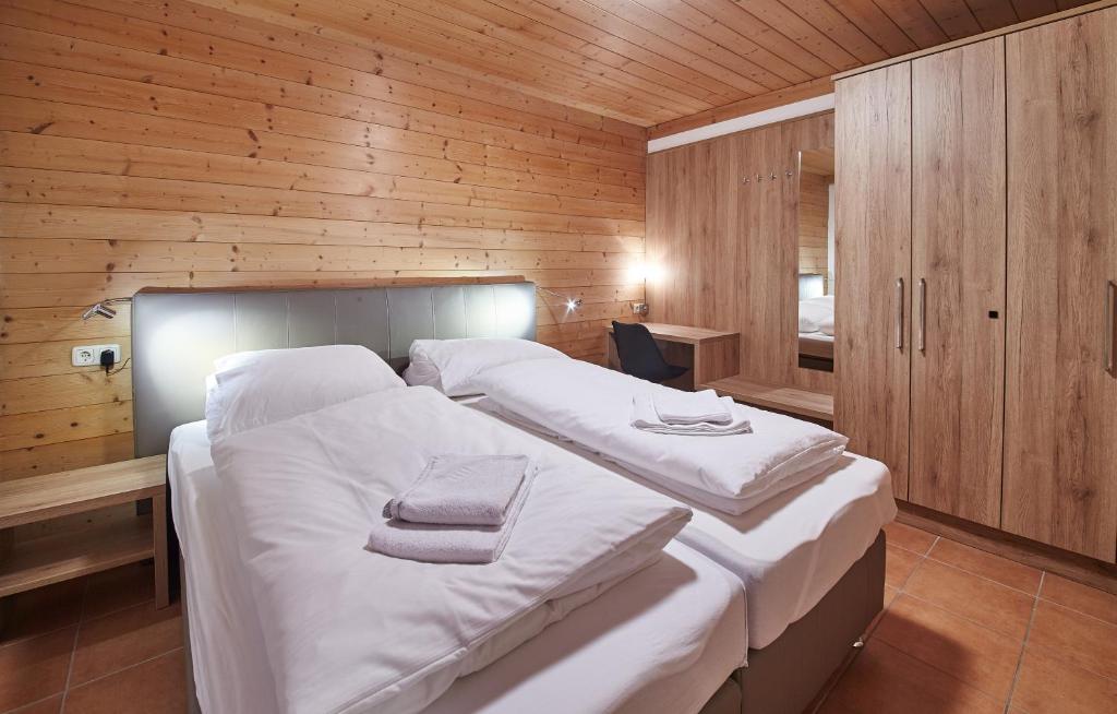 una camera da letto con un grande letto con lenzuola bianche di Appartement Kolling a Saalbach Hinterglemm