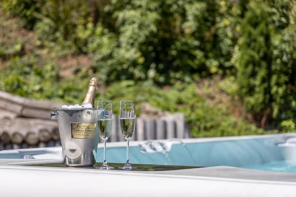 a table with two wine glasses and a bottle of champagne at Villa Trésor Voronet in Gura Humorului