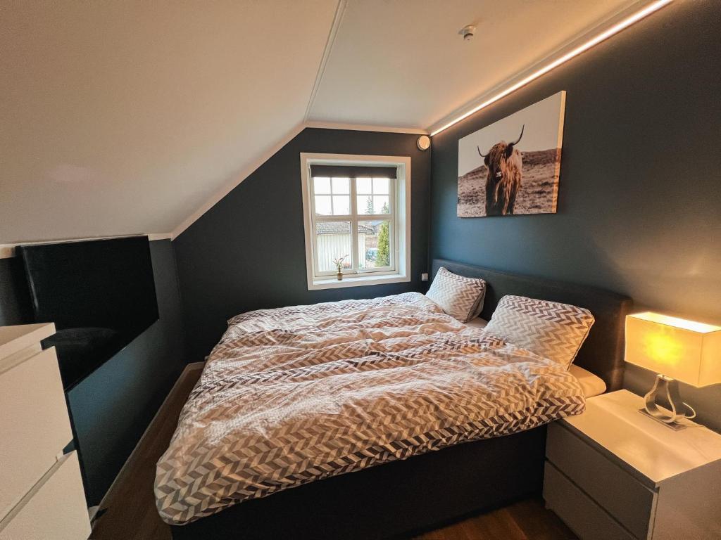 un dormitorio con una cama y una ventana en Sentralt og nyoppusset, en Skien
