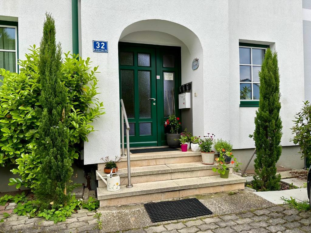 een groene deur op een wit huis met planten bij Ferienwohnung Gabriel in Rust