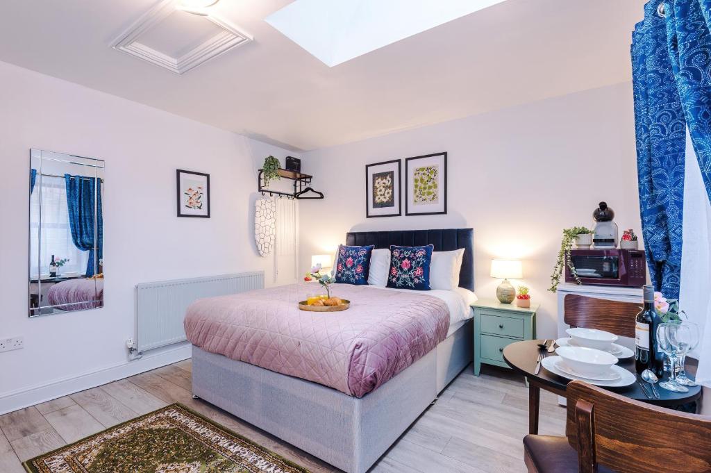 a bedroom with a bed and a table and chairs at Victoria Park Studio 11 - Free Parking, WiFi, Near Town Centre, Free DisneyPlus, Prime & Netflix in Leamington Spa