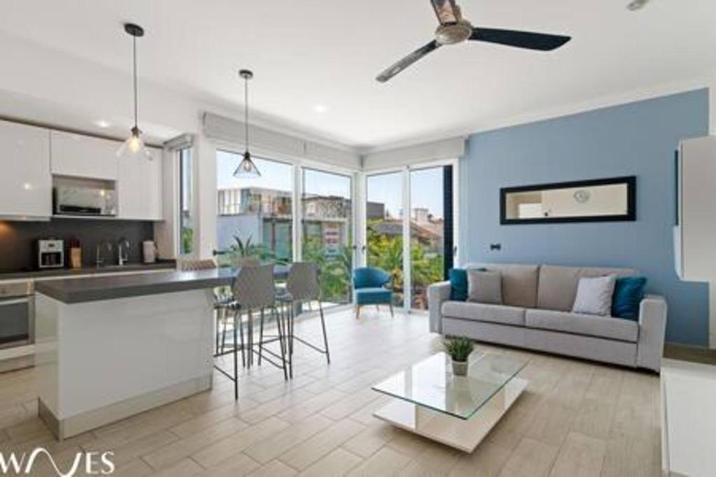 a kitchen and living room with a couch and a table at 1 Br. w5th avenue view Steps from the beach in Playa del Carmen