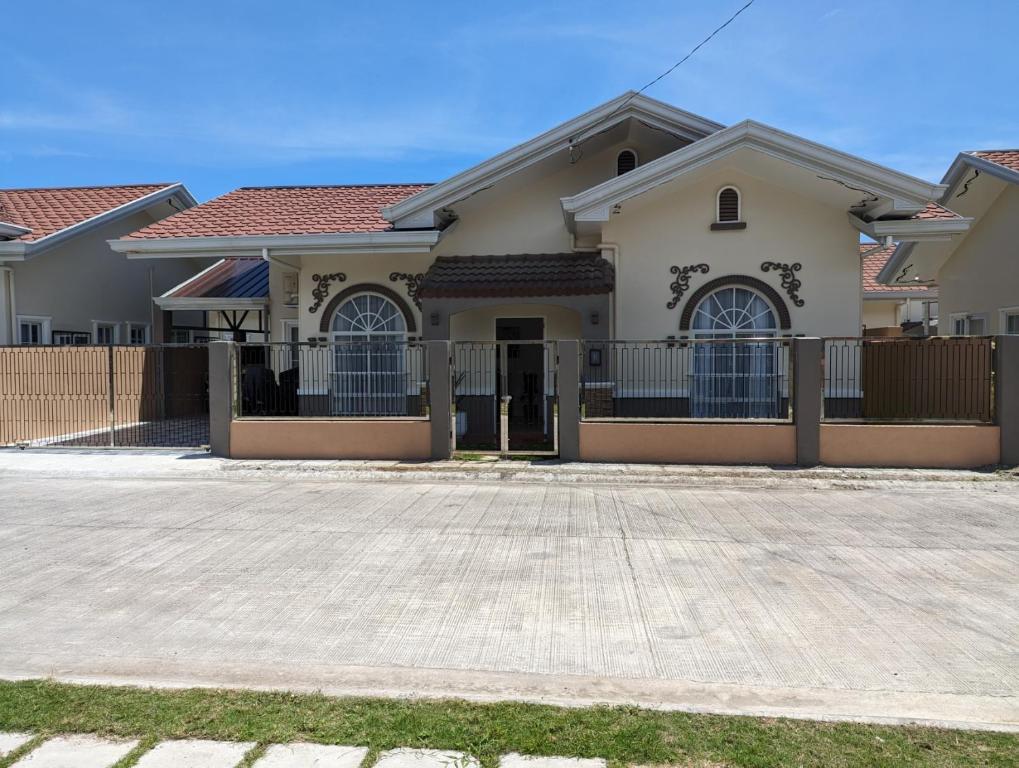 a house with a fence in front of it at Balay Hermosa in Dauis