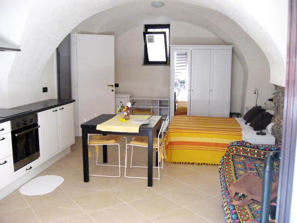 a kitchen with a table and a room with a bed at Nino Bixio Apartment in Riva Ligure