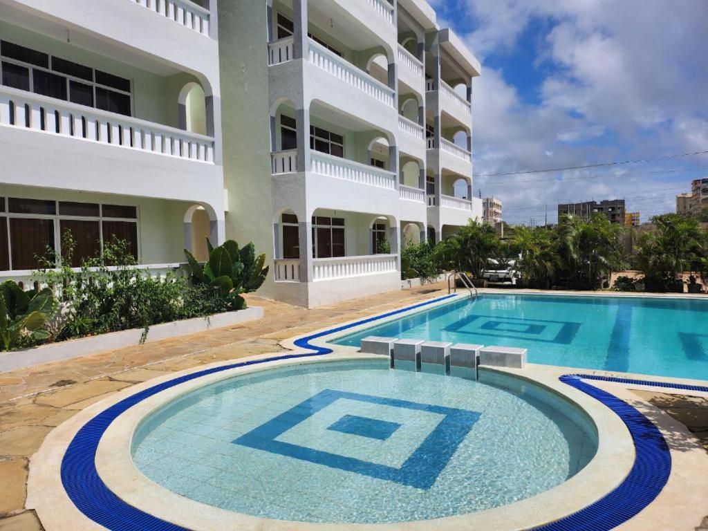 a swimming pool in front of a building at Mombasa Icon Apartment 2 in Mombasa