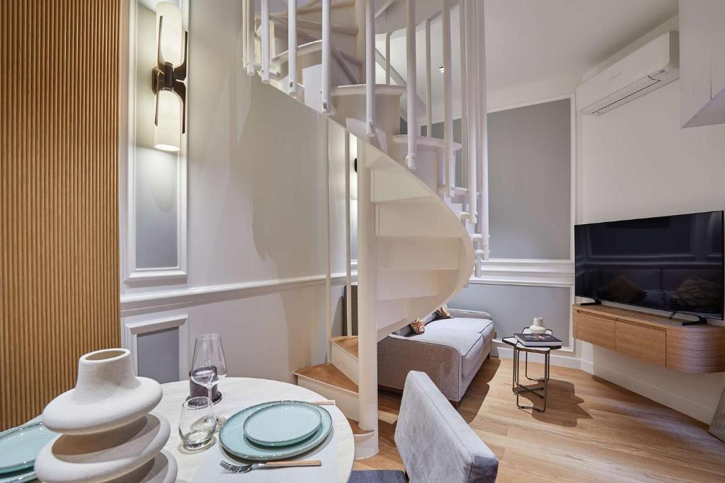 un salon avec un escalier en colimaçon et une table dans l'établissement Sublim 1BDR AC Arc de Triomphe Champs Elysees by Studio Prestige, à Paris