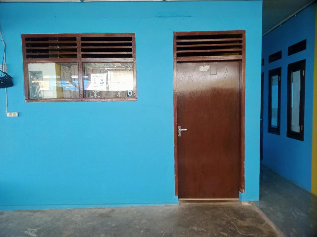 ein blaues Zimmer mit einer Tür und einem Fenster in der Unterkunft Anti Guest House in Kalibata 1