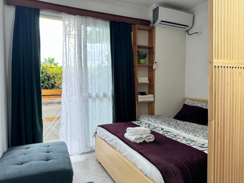 a small bedroom with a bed and a window at Studioo Apartment in Tirana