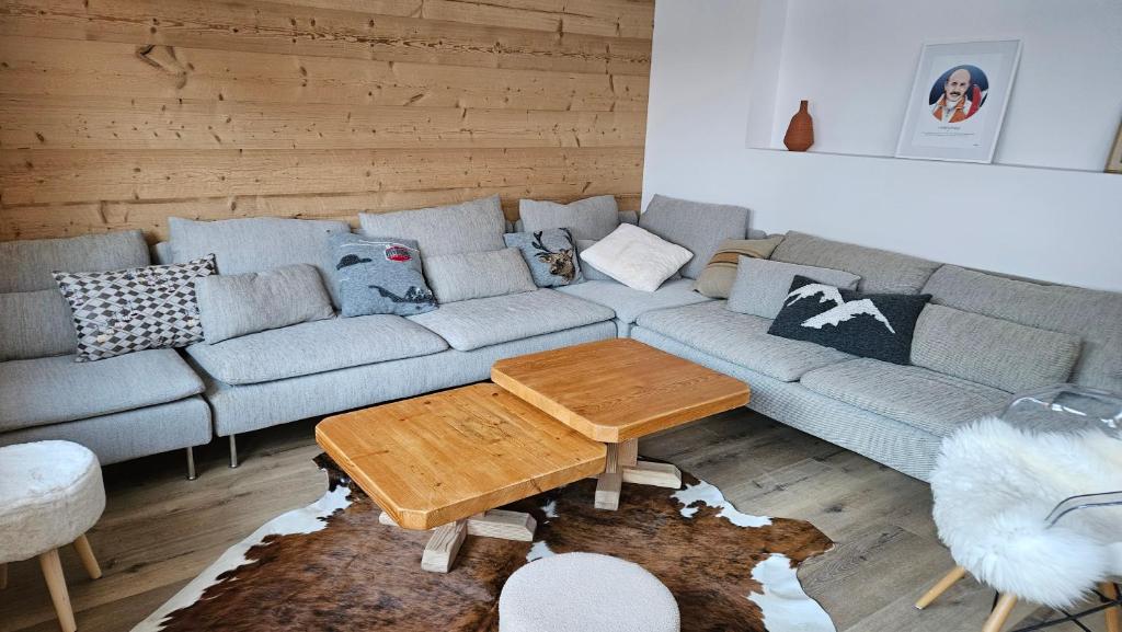 un salon avec un canapé et une table dans l'établissement Grand appartement 200m2 au pied des pistes, à La Giettaz