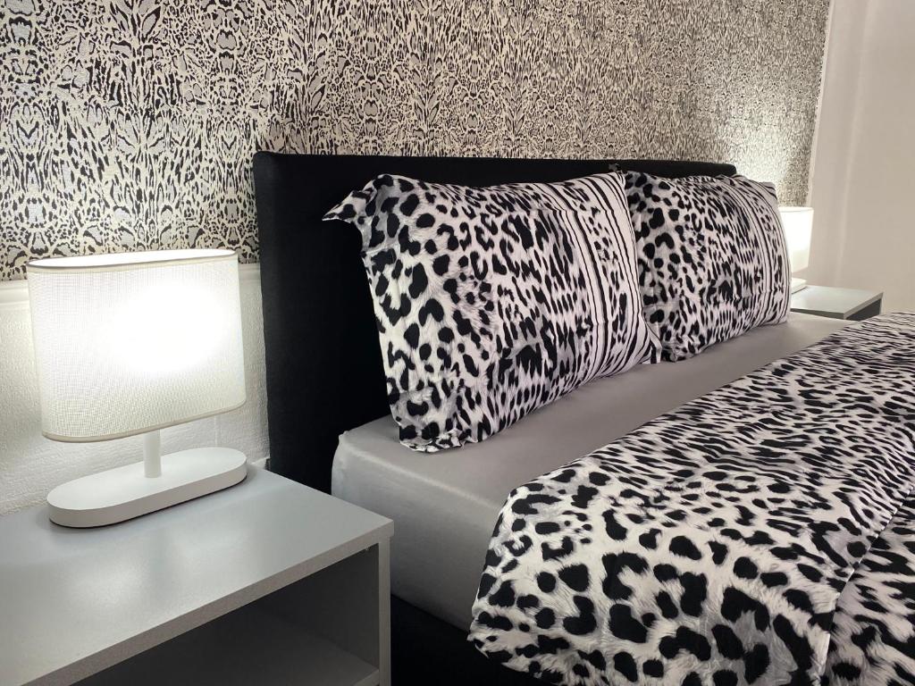 a bedroom with a black and white bed and a lamp at Guest house in avlabari in Tbilisi City