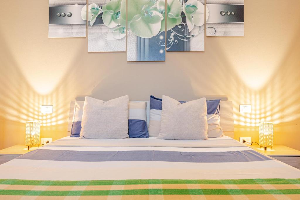 a bedroom with a bed with three paintings on the wall at Baracca Apartment in Massa Lombarda